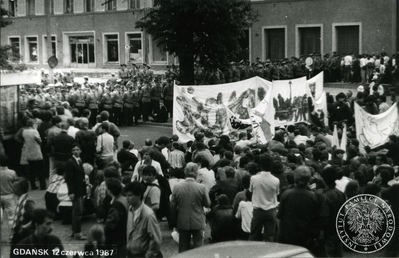 Zetknięcie się czoła pochodu demonstrantów z Solidarnościowymi transparentami z kordonem funkcjonariuszy MO przy ulicy ks. L. Miszewskiego w Gdańsku –Wrzeszczu. 12 VI 1987 r., IPN Gd 946/4