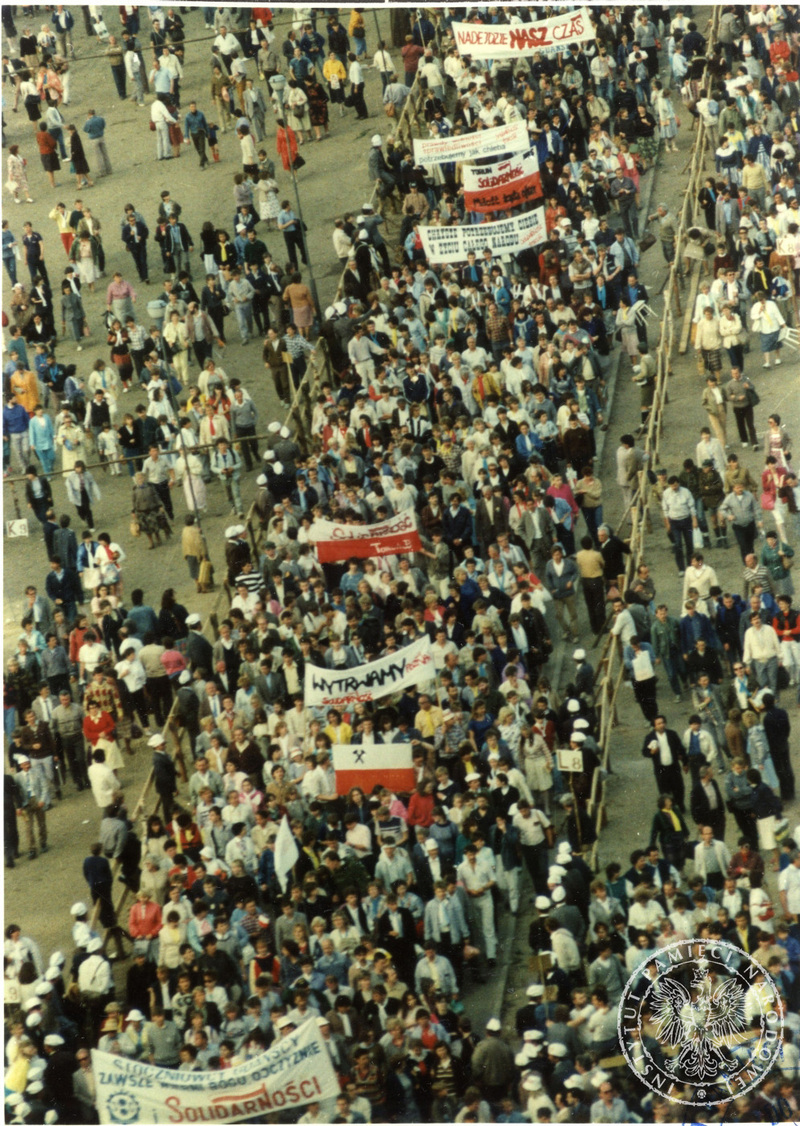 Demonstracja na ulicach Gdańska zorganizowana po mszy świętej na Zaspie, widoczny tłum ludzi z flagami i transparentami „Solidarności”, 12 VI 1987 r., IPN Gd 003/200 t. 7.