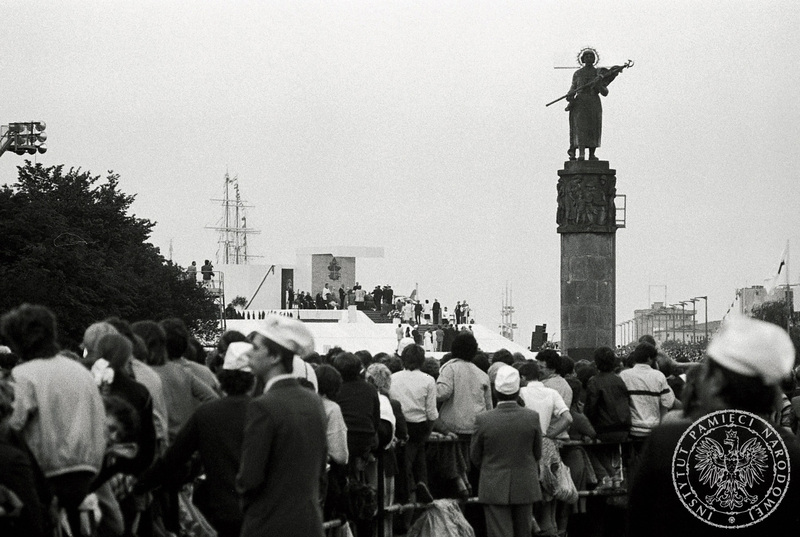Tłumy wiernych przy Skwerze Kościuszki obserwują spotkanie Jana Pawła II z ludźmi morza. Po prawej nieistniejący już pomnik- obelisk ku czci Żołnierzy Radzieckich tzw. Natasza.  W głębi po lewej podwyższenie na którym Jan Paweł II otoczony jest przez duchownych. 11 VI 1987 r. Sygnatura: IPNBU-7-7-8-161