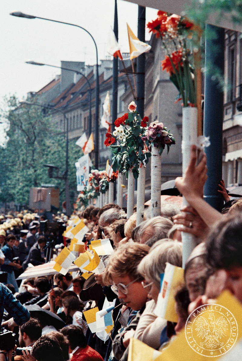 Wierni zgromadzeni na chodniku przystrojonym kwiatami Krakowskim Przedmieściu czekają na przejazd Jana Pawła II. 14 VI 1987 r. Sygnatura: IPNBU-7-7-8-301